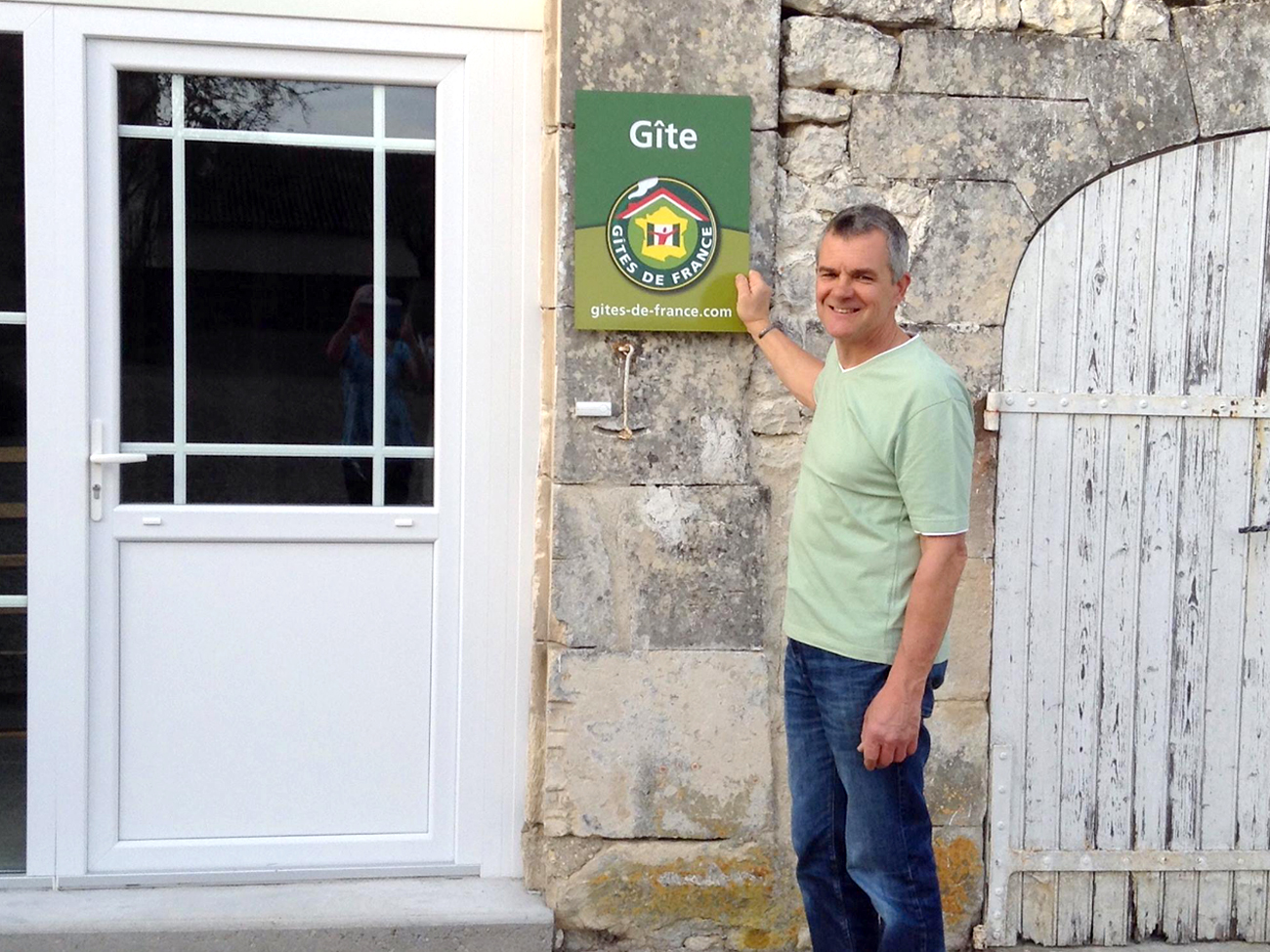 Tim Westacott accrochant sa plaque Gites de France