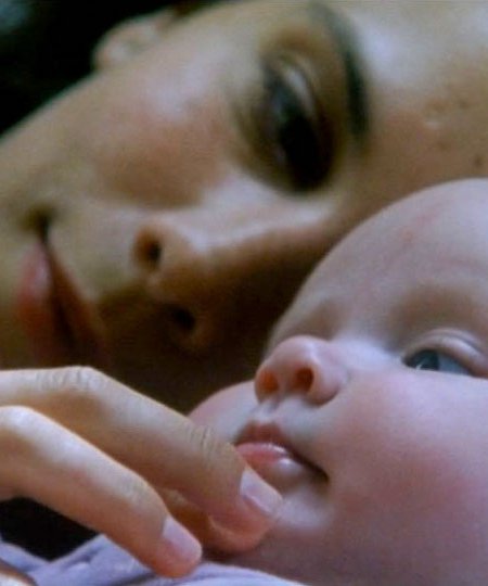 Claire caresse la joue de son bébé