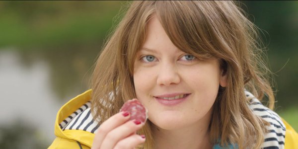 Femme sourit avec rondelle de saucisson - 100% pur porc