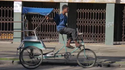 Un jeune homme sur un cyclo-pousse vide