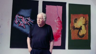 Roland Sénéca devant ses peintures