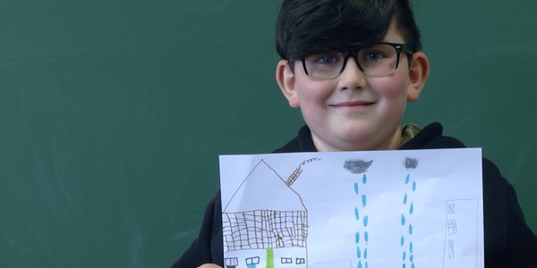 enfants écolier souriant avec son dessin retour à forbach SCAM