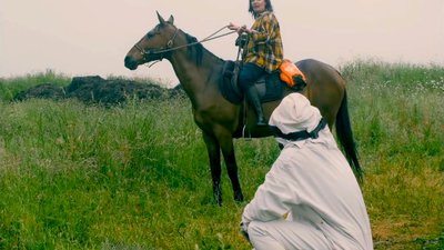Femme à cheval et homme en combinaison blanche