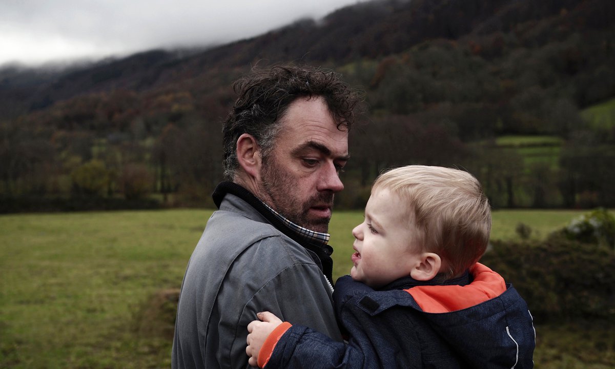 Père qui tient son fils dans ses bras Eric Courtet