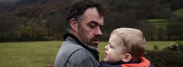 Père qui tient son fils dans ses bras Eric Courtet