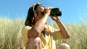 Un homme regarde à travers des jumelles - Le cavalier seul cover