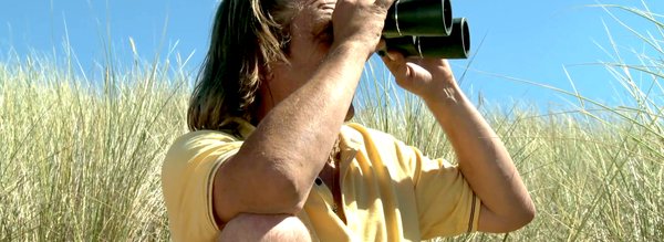 Un homme regarde à travers des jumelles - Le cavalier seul cover